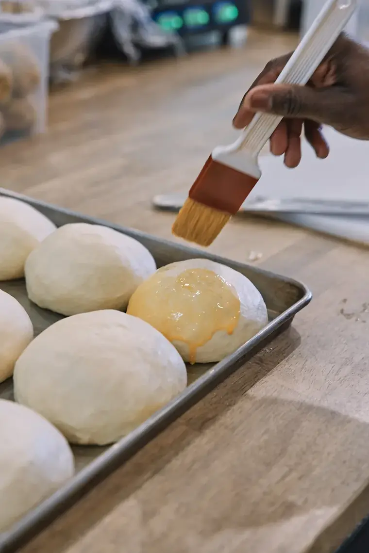 Brushing glaze onto rounded dough